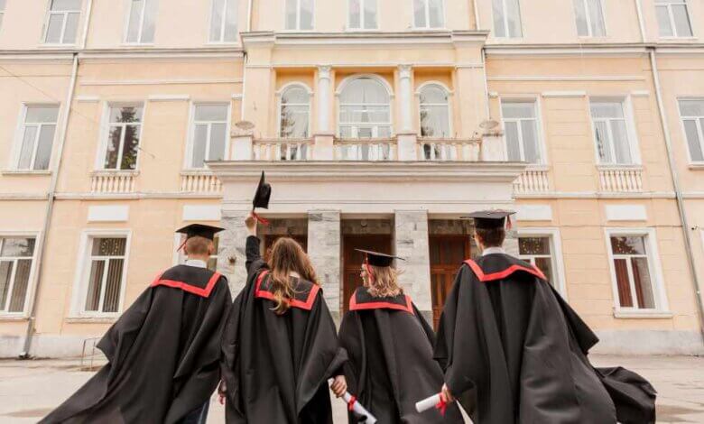 4 university students in convo gown showing their ba