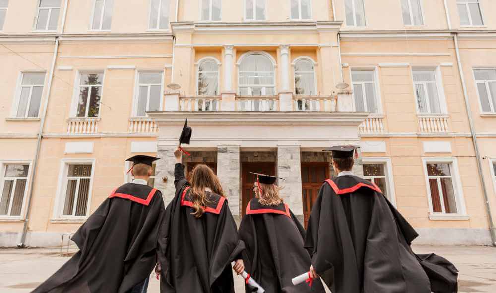 4 university students in convo gown showing their ba