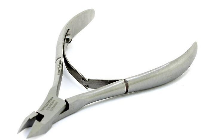 Tweezerman stainless steel cuticle nipper on a cutting mat