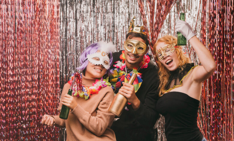 Three people in colorful costumes smiling and posing together for a photo at a birthday party photo booth in Texas.