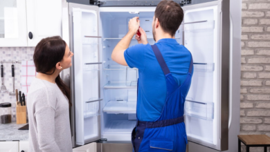 Refrigerator repair technician fixing appliance for homeowner