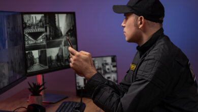 A man in a black shirt studies a computer screen, showcasing Trusted Site Security and Guard Patrol Services in Oakland.