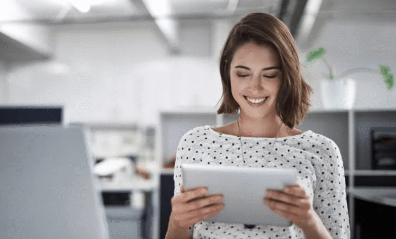A smiling woman using a tablet computer, engaged and enjoying her digital experience