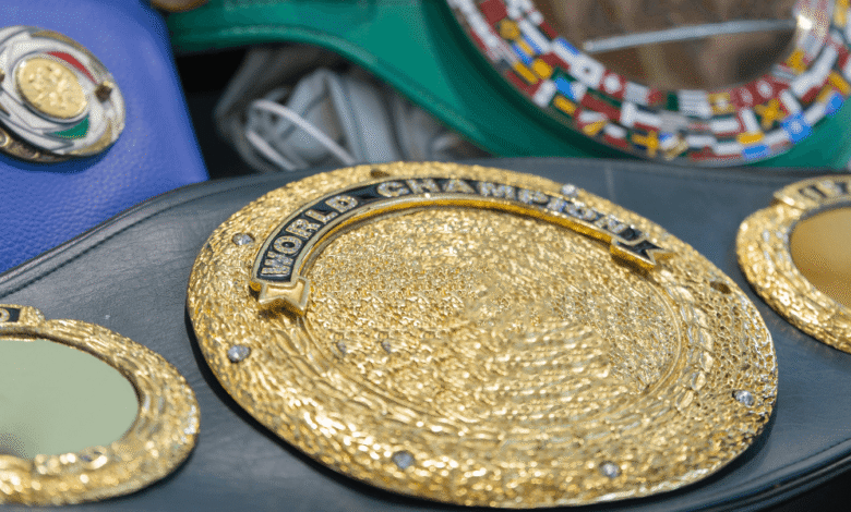 Close-up of a boxing belt featuring intricate gold detailing and a vibrant blue background.