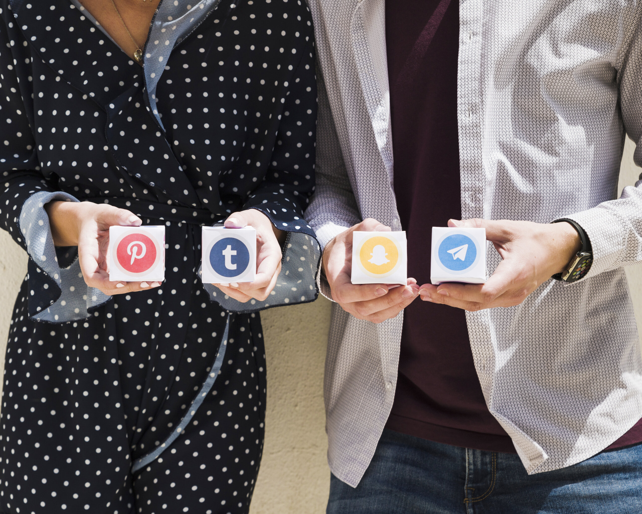 midsection-couple-holding-boxes-social-media-icons
