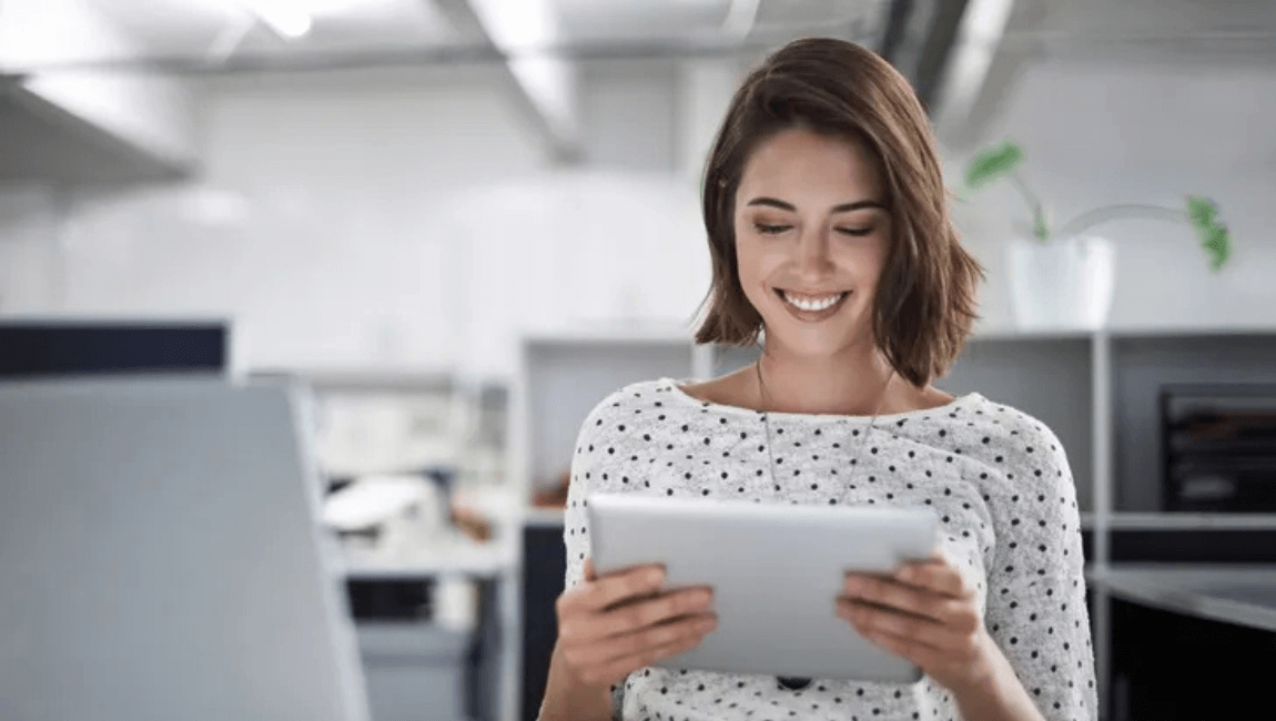 A smiling woman using a tablet computer, engaged and enjoying her digital experience